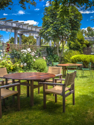 MARLBOROUGH, NEW ZEALAND - DECEMBER 6: Home backyard with garden table set in sunny a lush garden with shade of trees on a summer day