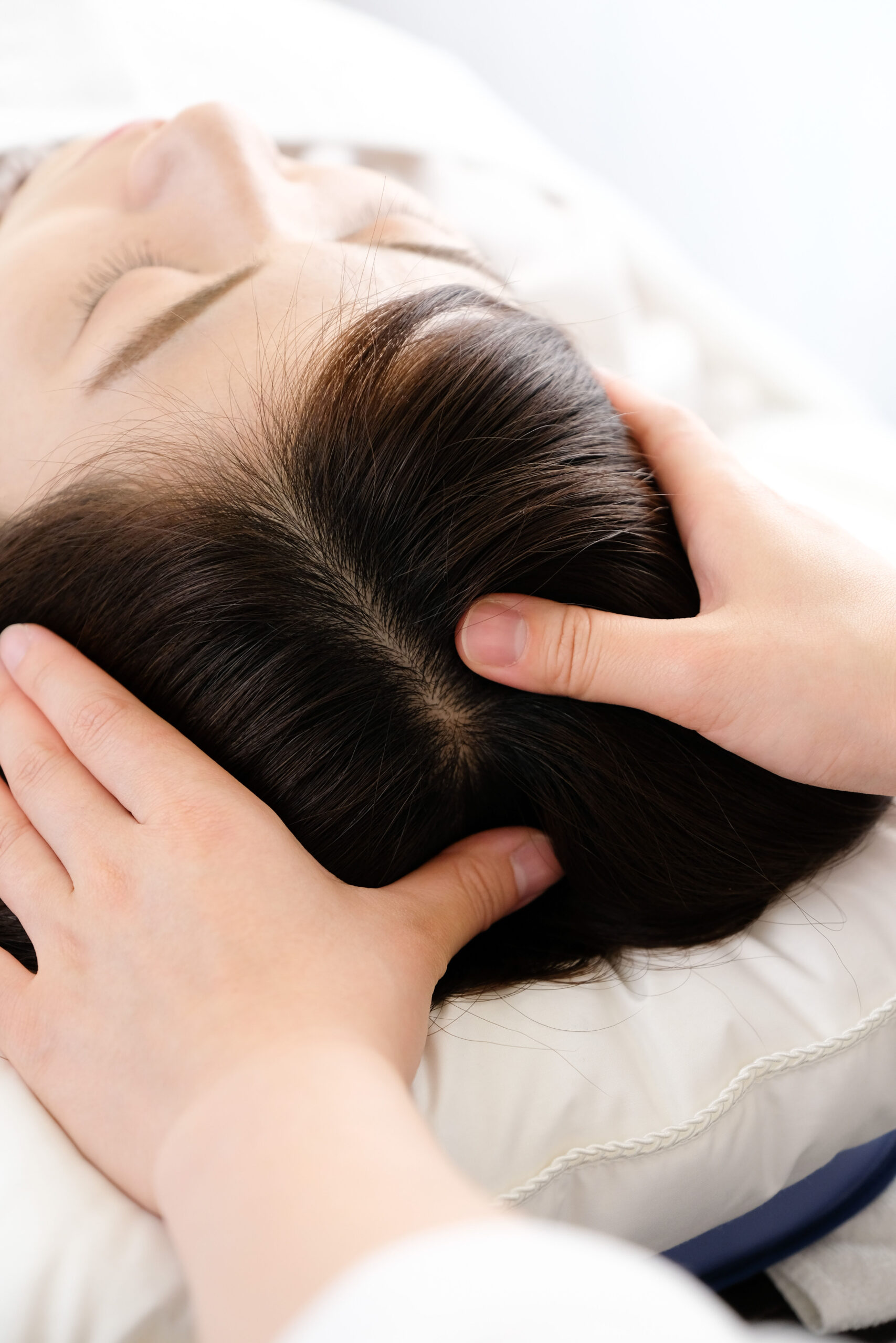 Client receiving a relaxing scalp ritual treatment and therapeutic head massage from an Artysto hair specialist.