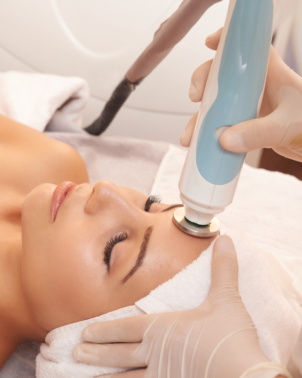 Professional skin care expert performing an advanced facial treatment with specialized equipment on a client at Artysto Salon.